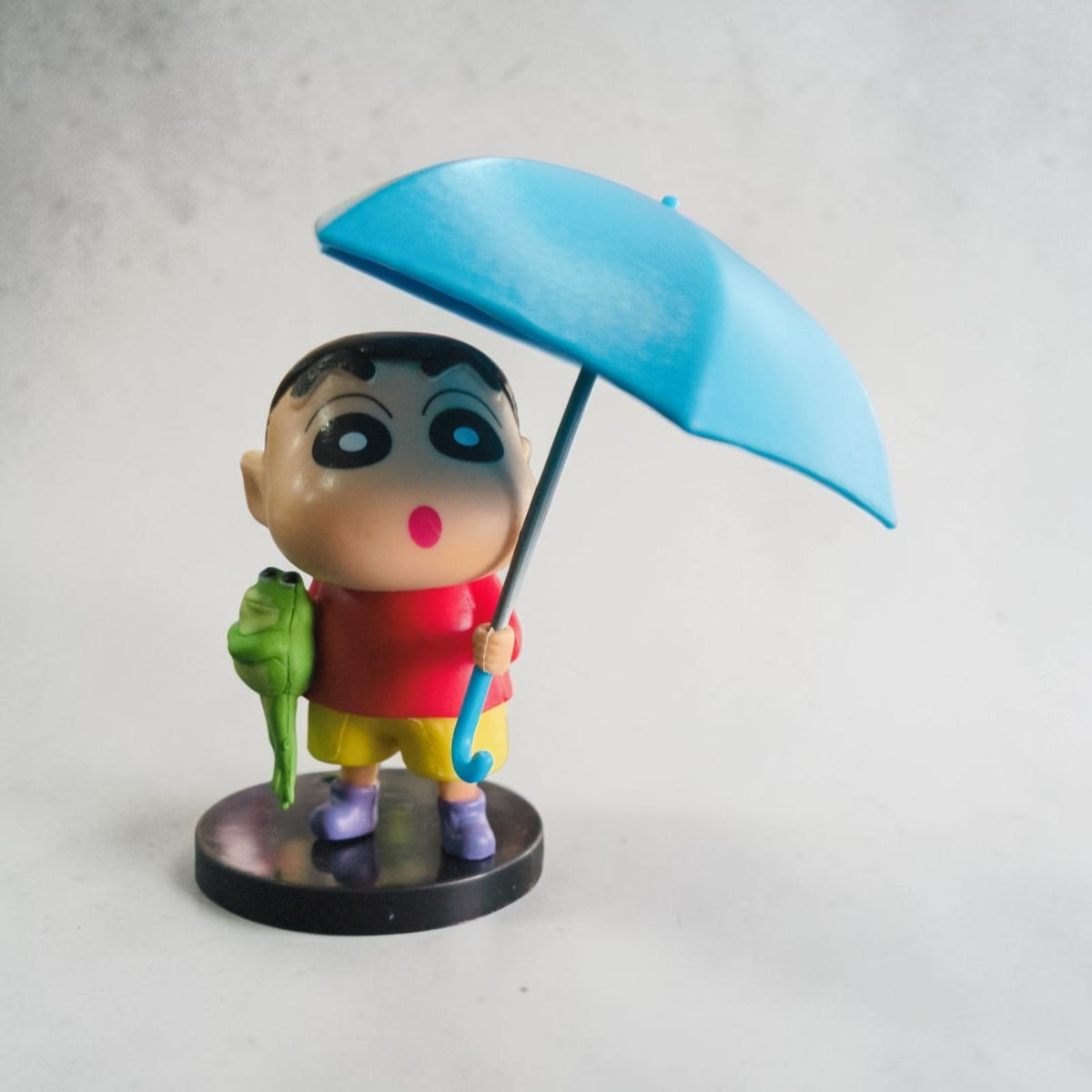 Shinchan Rainy Day Figurine with Umbrella & Frog – Cute Cartoon Collectible ( 9 CM)